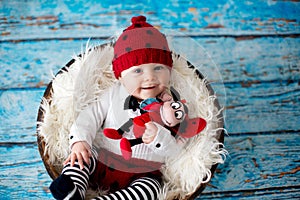 Little baby boy with knitted ladybug hat and pants in a basket