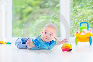 Little baby boy playing with colorful ball and toy car
