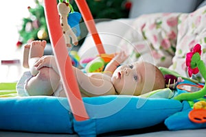 Little baby boy, playing with colorful toys at home