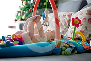 Little baby boy, playing with colorful toys at home