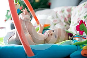 Little baby boy, playing with colorful toys at home