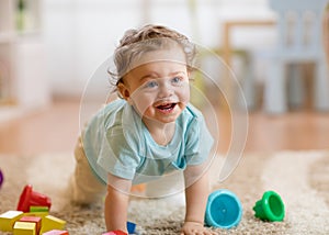Little baby boy playing and crawling on the floor at home