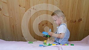 A little baby boy plays with his toys on the sofa in sunny room