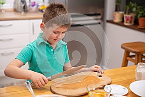 Little baby boy is reaching kitchen knife - danger in kitchen