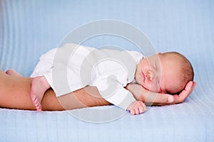 Little baby boy sleeping in arms of his father