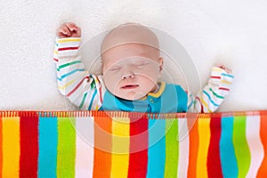 Little baby boy sleeping under colorful blanket