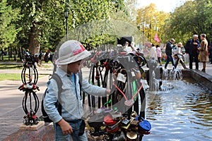 Little baby boy walking considering the decorations on the decorative railing of the fountain in the first square in Novosibirsk