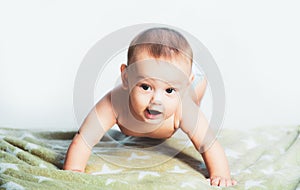 Little baby crawling on the bed. Happy kid playing. Cute little baby in diaper. Beautiful smiling cute child. Portrait