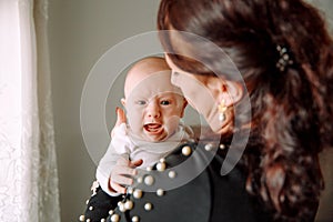 Little baby crying in mom`s arms