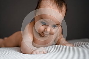 Little baby daughter on bed. One month age. Newborn cute happy beautiful girl smiling. Breast-feeding. Happiness for