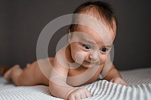 Little baby daughter on bed. One month age. Newborn cute happy beautiful girl smiling. Breast-feeding. Happiness for