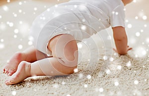 Little baby in diaper crawling on floor