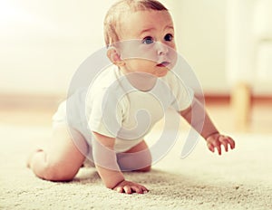 Little baby in diaper crawling on floor at home