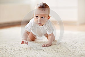 Little baby in diaper crawling on floor at home