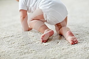 Little baby in diaper crawling on floor at home photo