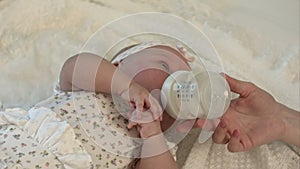 Little baby drinking milk from bottle