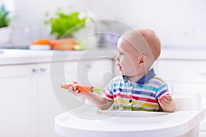 Little baby eating carrot