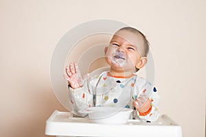 A Little baby eating her dinner and making a mess