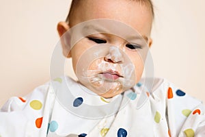 A Little baby eating her dinner and making a mess