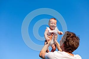 Little baby in father`s arms against blue sky , father`s day, fatherhood, happy