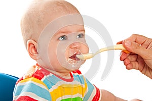 Little baby is feeding curds from spoon