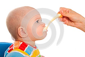 Little baby is feeding curds from spoon