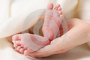 Little baby feet in mamas hands