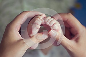 Little baby feet with mother hand
