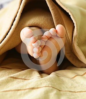 Little baby feet under a warm blanket