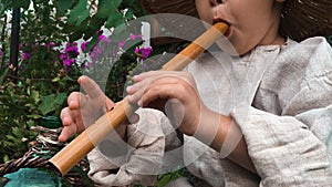 Little baby fingers playing on wooden little flute. Close up view of caucasian children`s fingers playing on music instrument