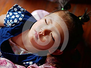 Little baby girl, 2 years old, sleeping in her mother`s arm