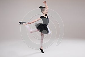Little baby girl ballerina dancing in black and white clothing smiling having positive emotion