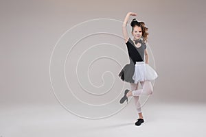 Little baby girl ballerina dancing in black and white clothing smiling having positive emotion