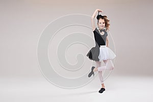 Little baby girl ballerina dancing in black and white clothing smiling having positive emotion