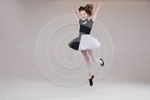 Little baby girl ballerina dancing in black and white clothing smiling having positive emotion