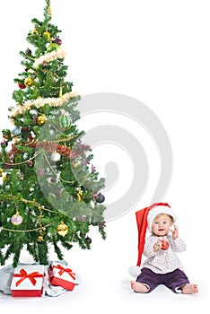 Little baby girl with a Christmas tree and a ball