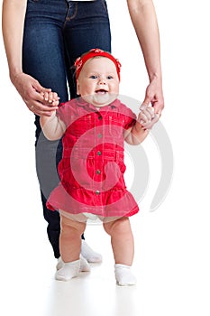 Little baby girl doing first step with mother