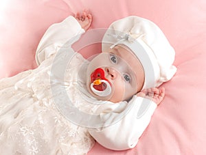 Little baby girl dressed in suit with pacifier