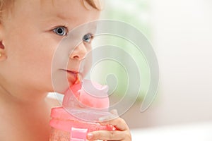 Little baby girl drinks juice from a bottle