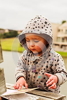 A little baby girl examines a book