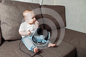 Little baby girl holding in hands big headphones