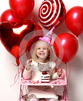 Little baby girl kid celebrate birthday with sweet cake and candies