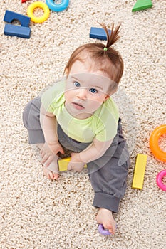 Little baby girl in middle of toys