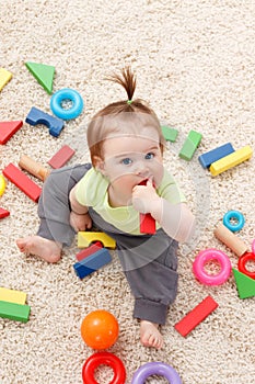 Little baby girl in middle of toys