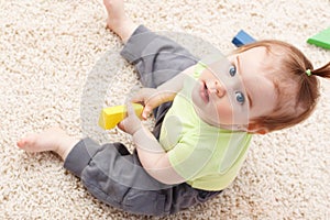 Little baby girl in middle of toys photo