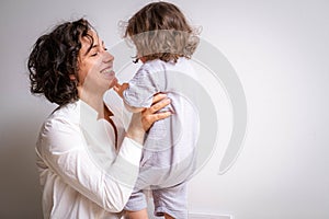 Little baby girl and mommy playing at home sitting on floor, mother and daughter laughing having fun together