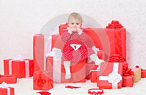 Little baby girl play near pile of gift boxes. Family holiday. Christmas gifts for toddler. Gifts for child first