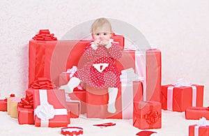 Little baby girl play near pile of gift boxes. Family holiday. Christmas gifts for toddler. Gifts for child first