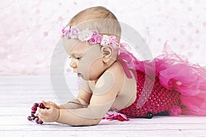 Little baby girl playing with beads