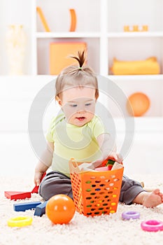 Little baby girl playing with toys photo